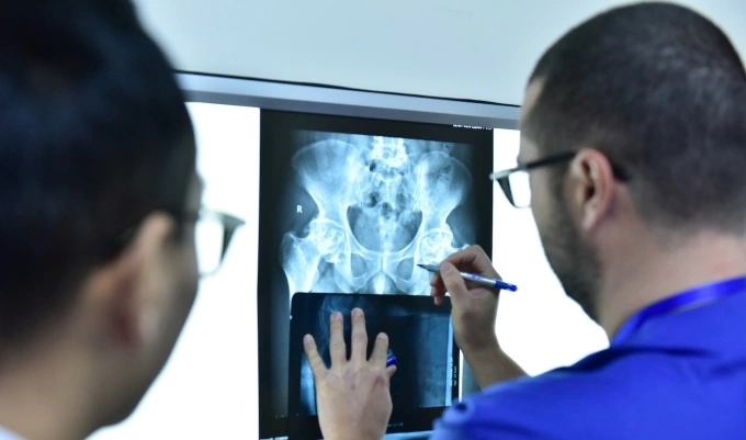 Bác sĩ Bệnh viện Quân y 175 và Tổ chức Operation Walk Chicago kiểm tra phim chụp trước mổ thay khớp háng. Ảnh: Bệnh viện cung cấp