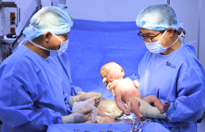 ThS.BS.CKII Lê Thanh Hùng, Phó khoa Sản, Trung tâm Sản Phụ khoa, Bệnh viện Đa khoa Tâm Anh TP HCM (phải) mổ lấy thai cho chị Nương. Ảnh: Nguyệt Nhi