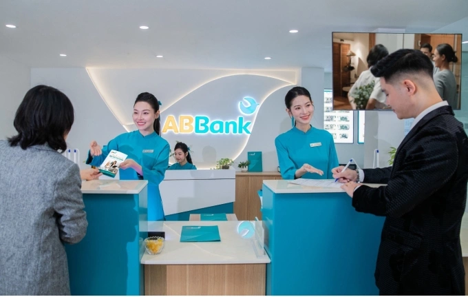 Nhân viên ABBank hỗ trợ khách hàng làm thủ tục tại quầy giao dịch. Ảnh: ABBank