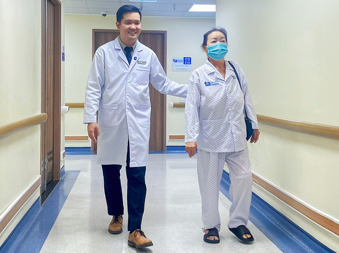 Bác sĩ Khoa hướng dẫn người bệnh đi lại ngày đầu sau mổ. Ảnh: Bệnh viện Đa khoa Tâm Anh