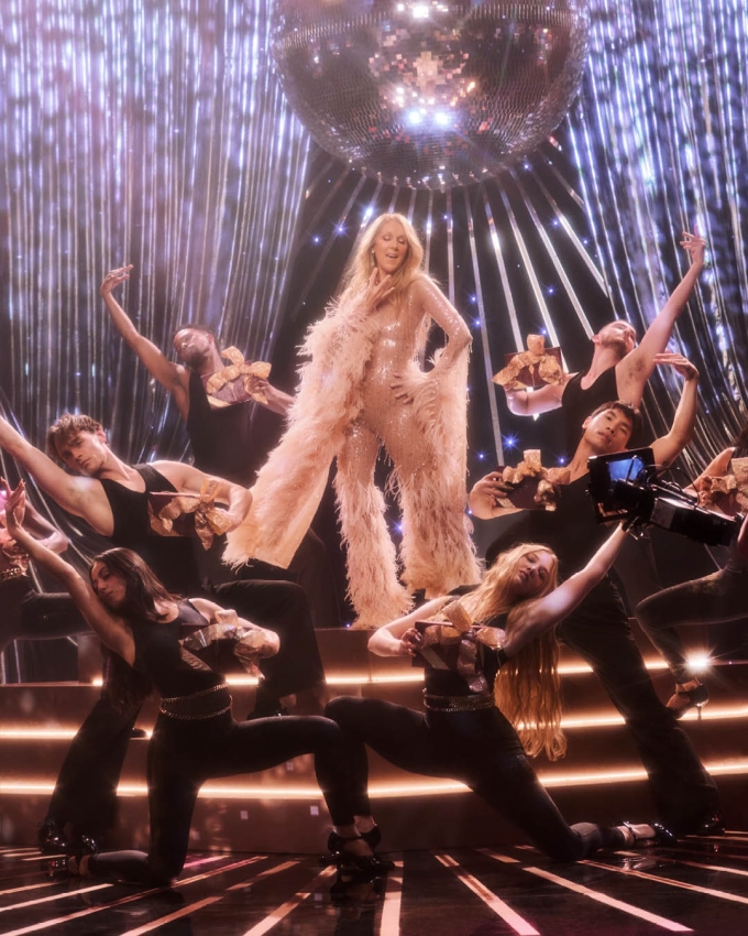 Celine Dion mặc jumpsuit tạo dáng bên các vũ công trên sân khấu phong cách disco trong một quảng cáo. Ảnh: Instagram Celine Dion