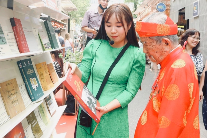 Nhà nghiên cứu Nguyễn Đình Tư, 106 tuổi, tham quan không gian triển lãm sách. Ảnh: Thu Giang