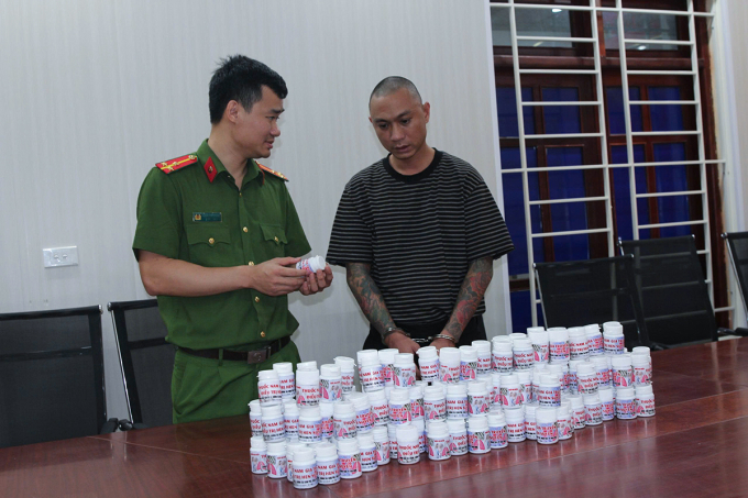 Nghi can Sơn (góc phải), cùng tang vật tại cơ quan điều tra. Ảnh: Công an cung cấp