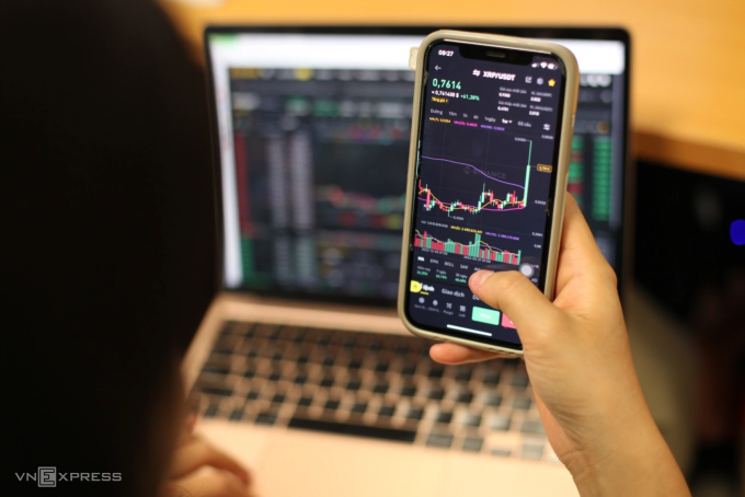 Một nhà đầu tư Việt đang theo dõi biến động giá của tiền mã hóa trên điện thoại. Ảnh: Khương Nha